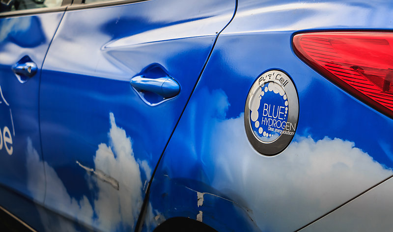 Close-up of logo on the blue bodywork of a hydrogen-powered taxi.
